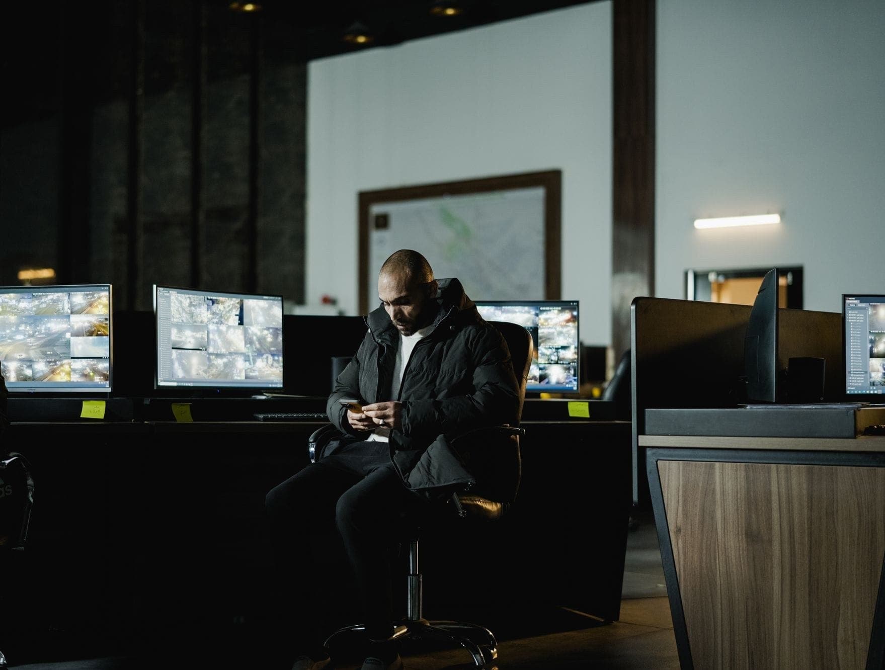 An operator watching a bank of CCTV monitors