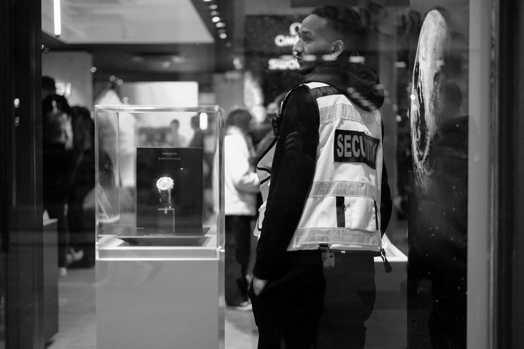 A security officer standing beside a display in a store